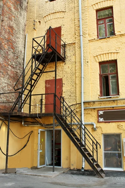 Металлическая лестница у стены дома — стоковое фото