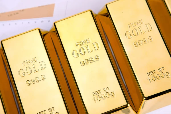 Gold bars on graphs and statistics — Stock Photo, Image