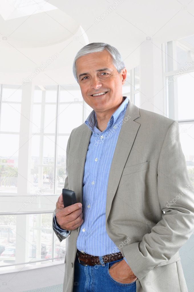 Businessman in Office Setting hodling Cell Phone