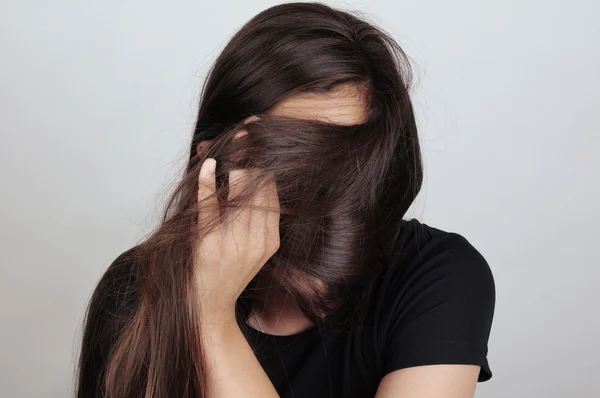 Chica tirando del pelo a través de la cara — Foto de Stock