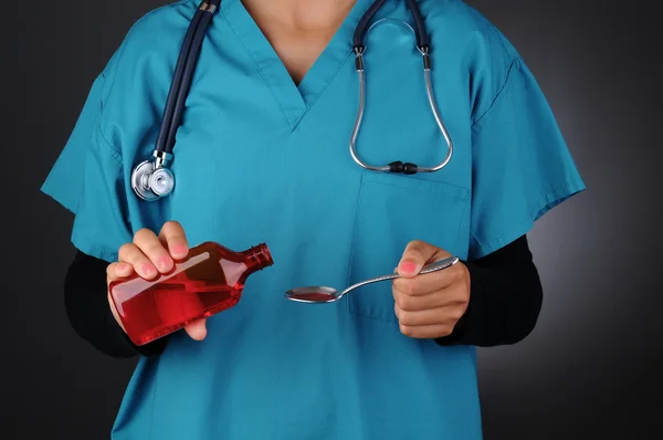 Verpleegkundige gieten geneeskunde op lepel — Stockfoto