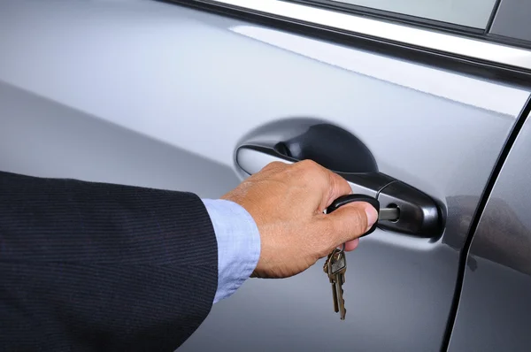 Adam arabanın anahtarını kapı kilit koyarak — Stok fotoğraf