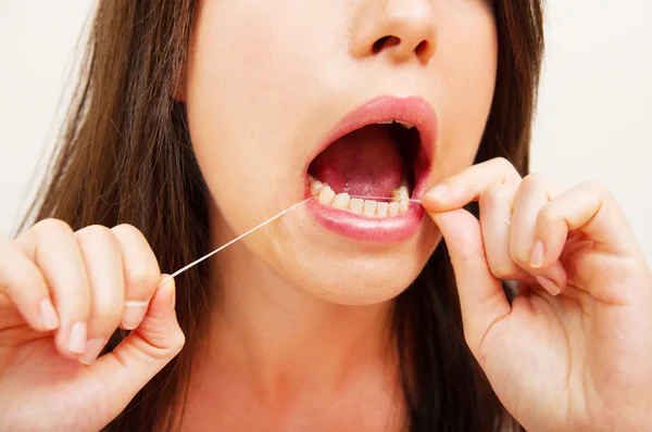Portrait d'une jeune femme en soie dentaire — Photo