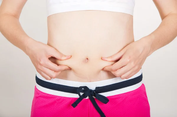Giovane adulto controllando il suo grasso ventre — Foto Stock
