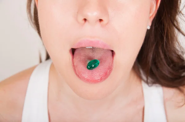 Jovem mulher tomando pílulas — Fotografia de Stock