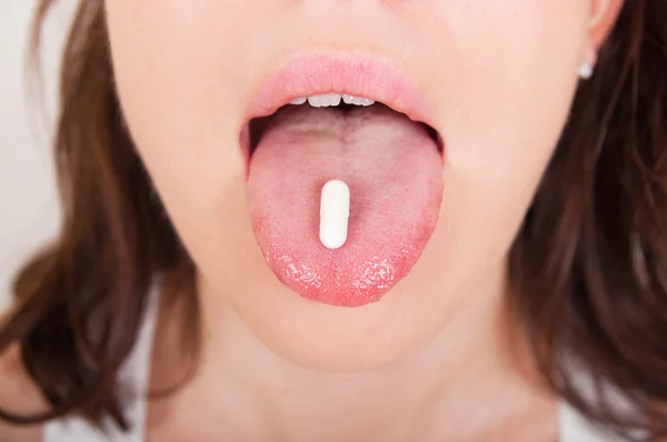 Jovem mulher tomando pílulas — Fotografia de Stock