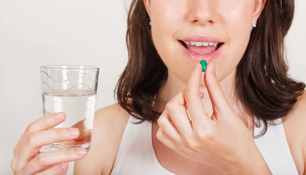 Young woman taking pills — Stock Photo, Image