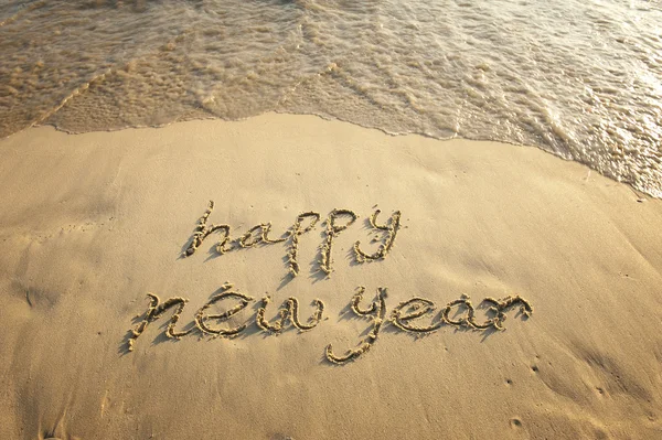Gelukkig nieuw jaar geschreven in het zand — Stockfoto
