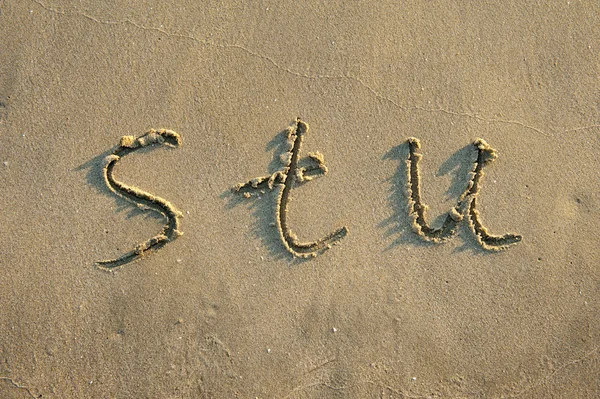 Litery alfabetu odręcznie napisane w piasku na plaży — Zdjęcie stockowe