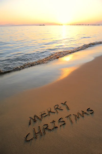 Vrolijk kerstfeest handgeschreven in zand op een strand — Stockfoto
