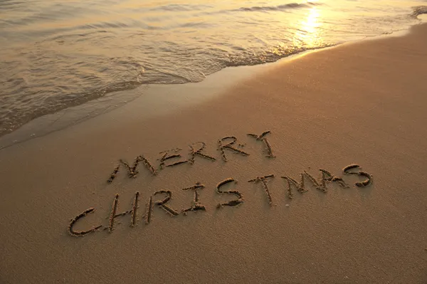 Vrolijk kerstfeest handgeschreven in zand op strand — Stockfoto