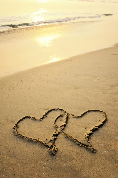 绘制的一个海滩的沙子上的两颗心 — 图库照片
