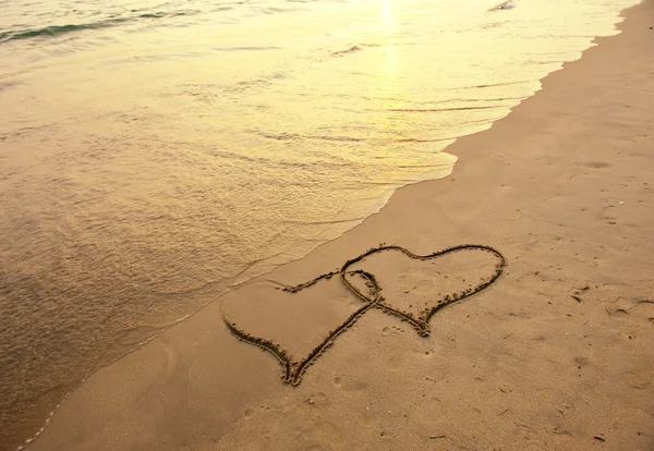 Zwei Herzen auf dem Sand eines Strandes gezeichnet — Stockfoto