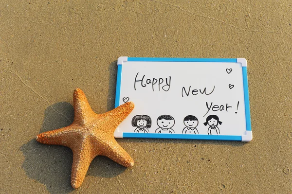 Happy new year message on the sand beach — Stock Photo, Image