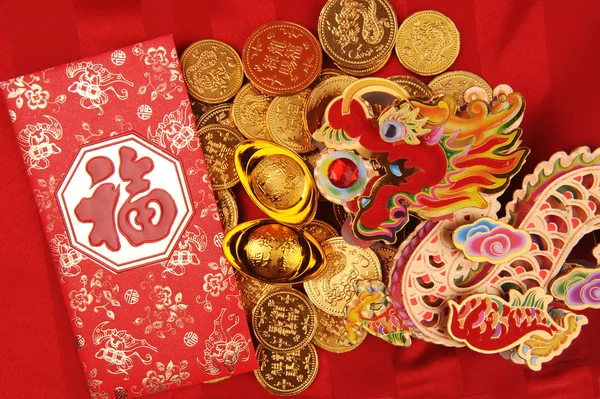 Kínai új év dísztárgy--hagyományos tánc sárkány arany érme és pénzt piros csomag, piros petárda — Stock Fotó
