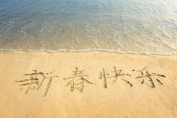 stock image Chinese Calligraphy for happy new year written in the sand