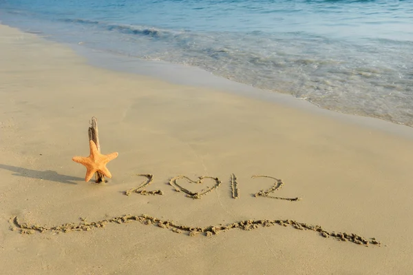 2012 mensaje de año nuevo en la playa de arena —  Fotos de Stock