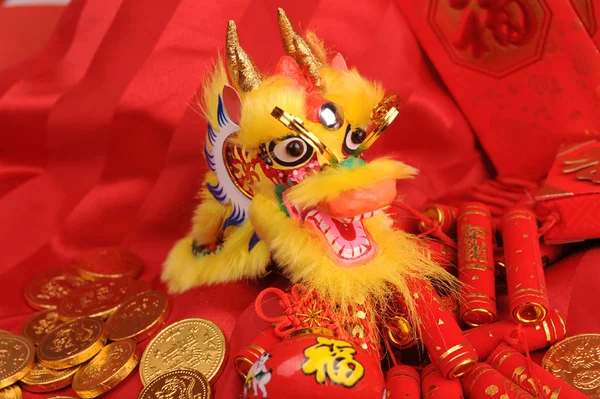Chinesische Neujahrsornamente - traditioneller tanzender Drache, goldene Münze und rotes Geldbündel, roter Feuerwerkskörper — Stockfoto