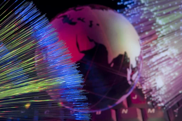 Computer gegevens concept met earth globe tegen fiber optic achtergrond — Stockfoto