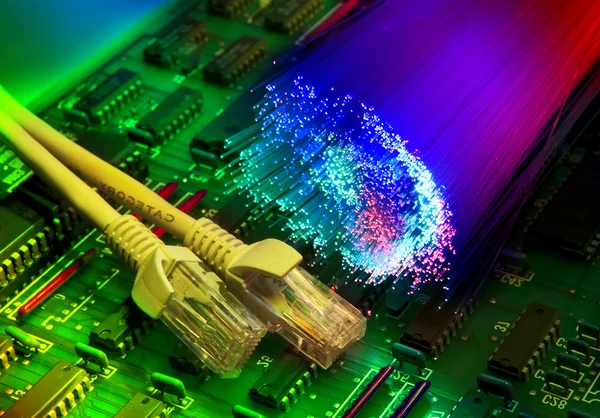 Placa de circuito impresso eletrônico com fechamento de cabo de rede em fundo de fibra óptica — Fotografia de Stock