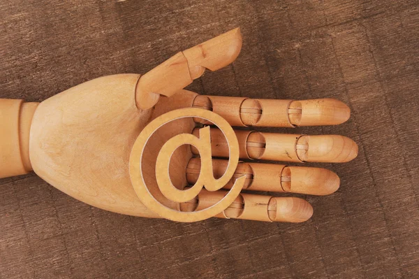 Wooden mannequins hands, holding email symbols — Stock Photo, Image