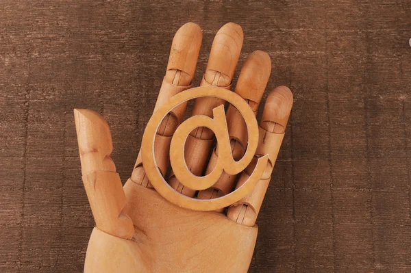 Wooden mannequins hands, holding email symbols — Stock Photo, Image