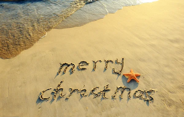 Vrolijk kerstfeest handgeschreven in zand op een strand — Stockfoto