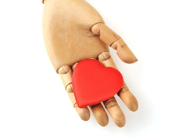 Wooden mannequin hands, holding red heart symbols — Stock Photo, Image