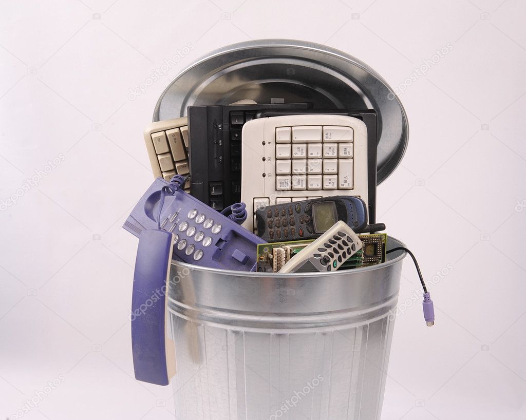 Different computer parts and phone in trash can
