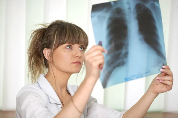 Sjukdom. kvinnliga läkare undersöka en röntgenbild — Stockfoto