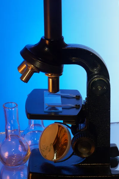 Microscope and laboratory glasswares — Stock Photo, Image