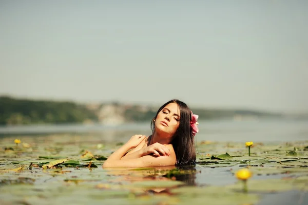 Sexig brunett kvinna i vatten i klädstil — Stockfoto