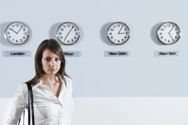 Businesswoman In Front Of World Time Zone Clocks — Stock Photo, Image