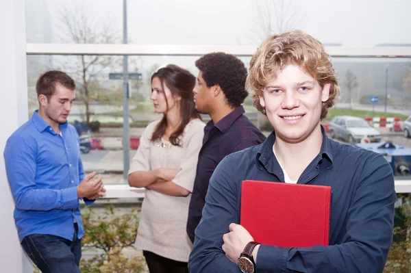 Usmívající se mladý muž na univerzitní kampus — Stock fotografie
