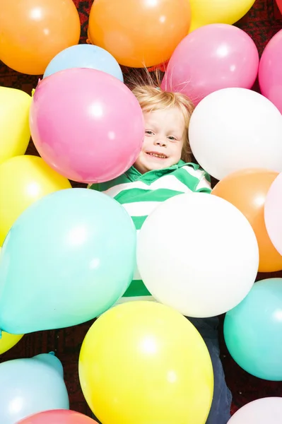 Boy surrounded by baloons — Stock Photo, Image