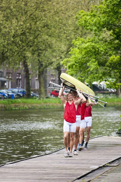 Oarsmen carrying a rowing boat — Stock Photo, Image