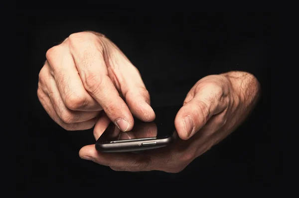 Человек, печатающий смс на смартфоне — стоковое фото