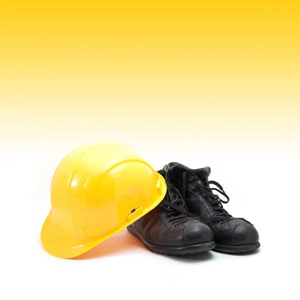 Chapéu duro amarelo e botas velhas — Fotografia de Stock