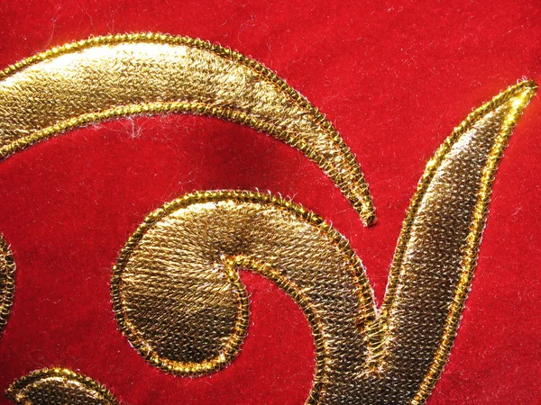 O aplique dourado em veludo vermelho — Fotografia de Stock