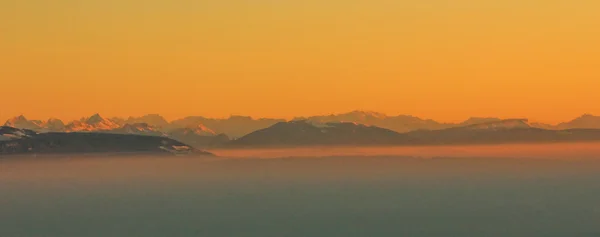 Alpler ve kar ve gökyüzü turuncu — Stok fotoğraf
