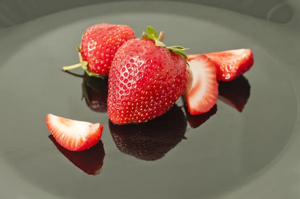 Erdbeeren auf einem dunklen Teller (flach dof) — Stockfoto