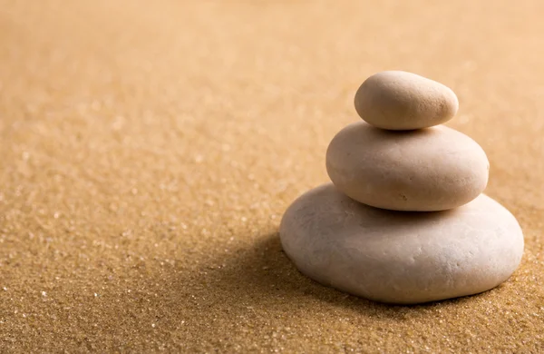 Three staked stones on sand — Stock Photo, Image
