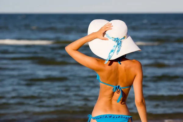 Sexy meisje in grote hoed op het strand — Stockfoto