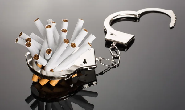Cigarettes locked to handcuffs — Stock Photo, Image
