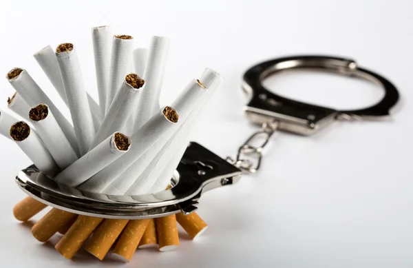 Сигареты, пристегнутые наручниками — стоковое фото