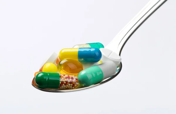 Colher cheia de vários comprimidos — Fotografia de Stock