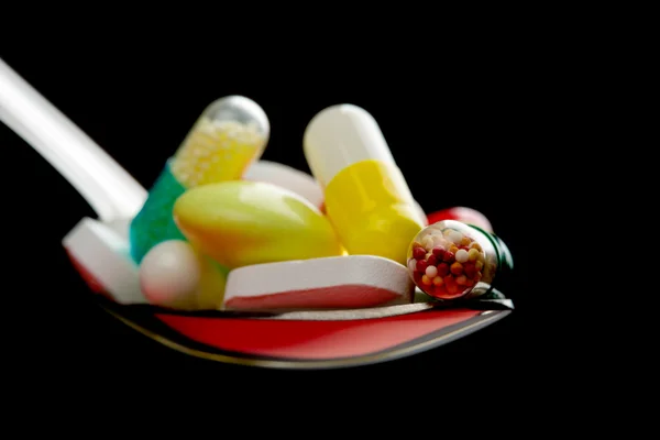 Ложка, полная различных таблеток — стоковое фото