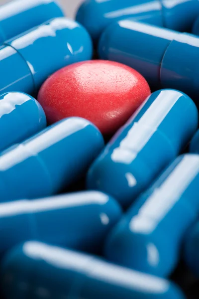 Red pill between blue capsules — Stok fotoğraf