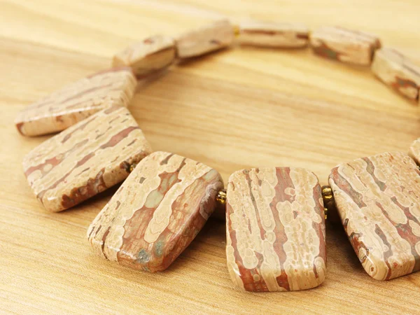 Halskette aus Jaspis auf Holz — Stockfoto