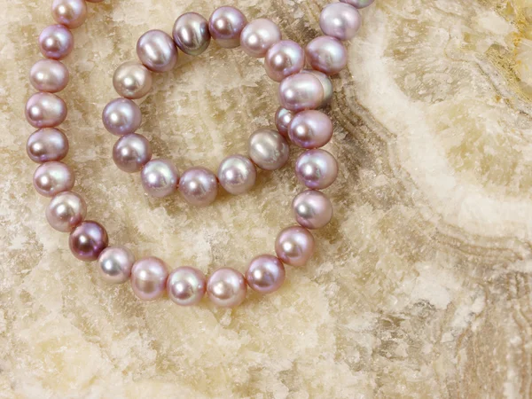 stock image Pearls necklace on a stone